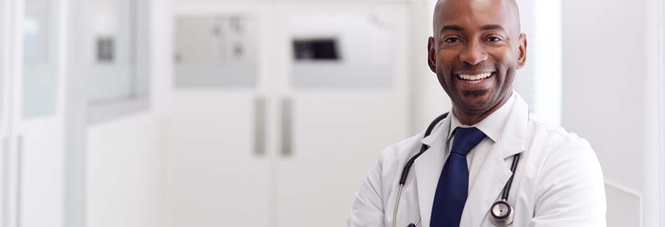 A Baptist heart transplant doctor wears a white coat and smiles